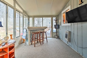 A room with a bar area, large windows, a television, and a fireplace. - Walk to Locust Lake - Poconos Home w Fire Pit! (Pocono Lake)