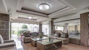 A modern living room with a glass coffee table, sofas, and a large mirror. - Cozy Standard Double w/ City View & Free WiFi (Bali)