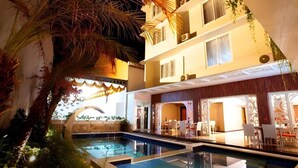 A hotel with a pool, outdoor seating, and a covered area with tables and chairs. - Cozy Standard Double w/ City View & Free WiFi (Bali)