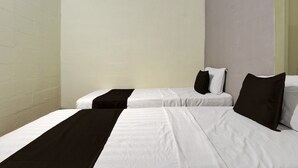 Een kamer met twee bedden, elk voorzien van witte beddengoed en zwarte accenten, en effen muren.