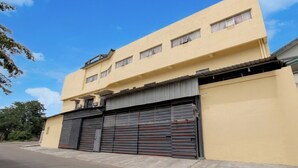 Een gebouw met twee verdiepingen, een gesloten garage en een plat dak.
