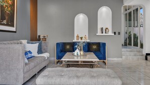 Ein modernes Wohnzimmer mit grauem Sofa, einem blauen Akzentsofa, einem Couchtisch und einer Deckenleuchte.