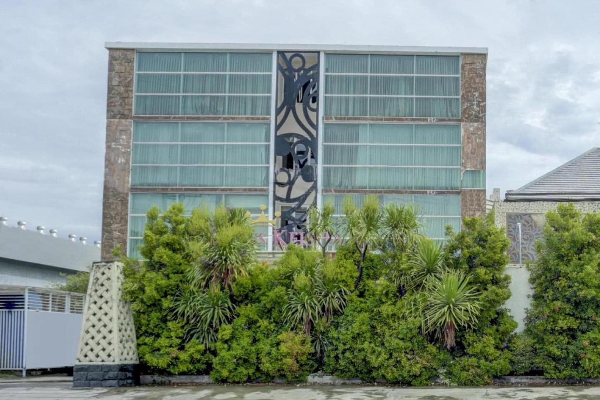 Un bâtiment moderne doté de grandes fenêtres et d’une façade décorative.