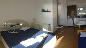 Un dormitorio con cama, mesita de noche y un pequeño escritorio con silla.