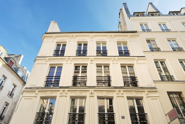 A multi-story building with a classic architectural style, featuring balconies and large windows. - Charming Suite with AC - Center of Paris (Paris)
