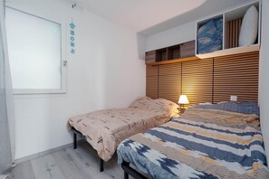 A bedroom with a bed, a bedside table, a lamp, a window, and a wall-mounted shelf with pillows. - Sophisticated Retreat Near the Sea, Agde (Agde)
