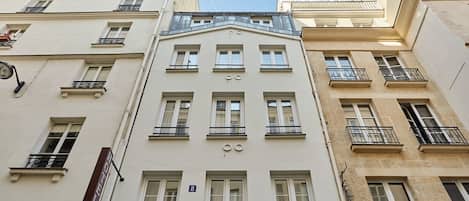 A multi-story building with a classic architectural style, featuring symmetrical windows and balconies.