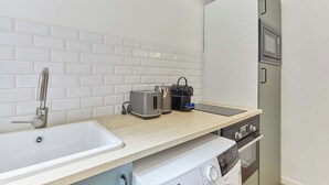 Eine Küche mit Spüle, zwei Toastern, einem Wasserkocher, einer Mikrowelle und einem Geschirrspüler.