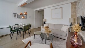 Ein modernes Wohnzimmer mit Essbereich, einer Couch und einem Couchtisch.