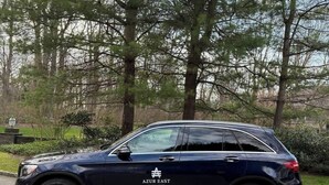 A dark blue SUV parked on a paved road with a wooded area in the background. - Home 2 mins. from Shinnecock Golf town SH beaches (Southampton)