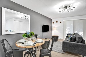 A modern dining area with a round table, chairs, a potted plant, and a 'DO NOT DISTURB' sign.