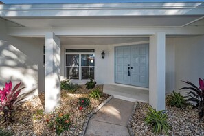 A house with a covered porch, a light blue door, and a window. - Luxury Modern Home - 8 minutes from the Beach (Largo)