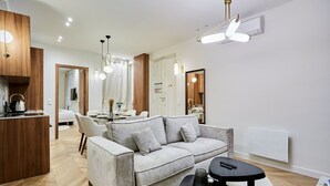 A modern living room with a sofa, a dining area, and a kitchen. - Beautiful apartment with AC - Center of Paris (Paris)