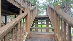 A wooden staircase leading to a covered area with railings on both sides. - The Sunset Perch | Pet-Friendly + Deck (Eureka Springs)