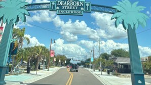 Señal de calle indicando West Dearborn Street en Englewood, con palmeras a ambos lados.