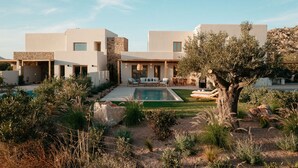 A modern villa with a swimming pool, outdoor seating, and a stone wall. - VILLA KERAMEAS PLAKA NAXOS (Plaka)