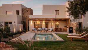 A modern house with a pool, outdoor seating, and a stone wall. - VILLA KERAMEAS PLAKA NAXOS (Plaka)