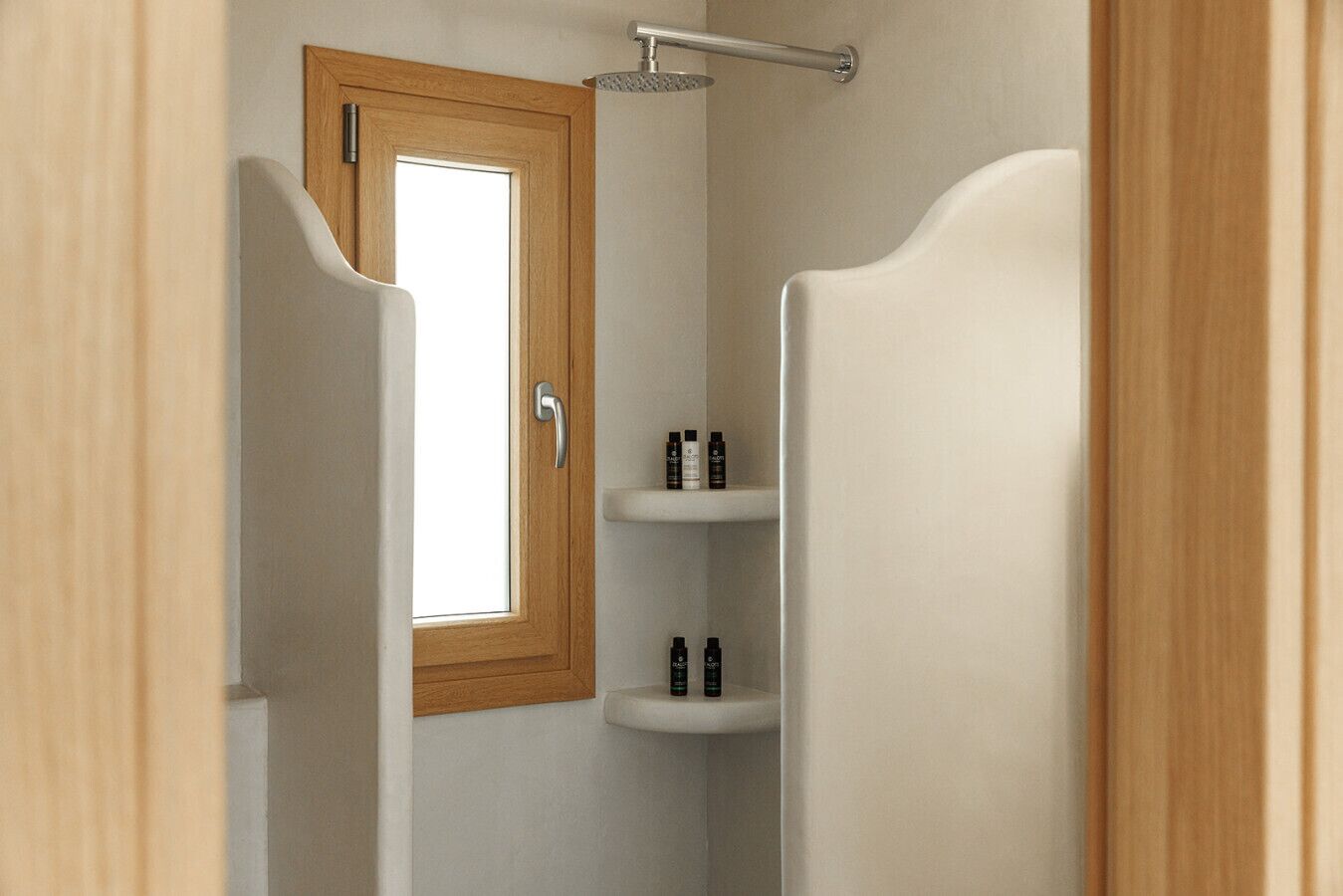 A bathroom with a shower, a door with a window, and two shelves with toiletries.