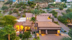 A two-story house with a patio, a garage, and a view of a hill with other buildings. - NEW | HTD Pool | Firepit | Biltmore | Piestewa (Phoenix)