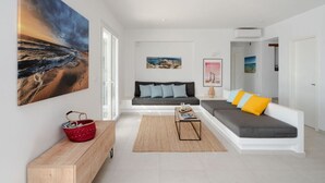 Ein modernes Wohnzimmer mit einer Couch, einem Couchtisch und einem Gemälde an der Wand.