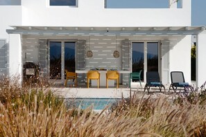 A modern house with a pool, outdoor seating, and a covered patio area. - Villa Aura Kastraki NAXOS (Kastraki)