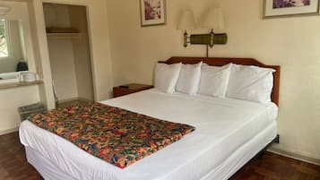 Habitació d'hotel amb un llit, una tauleta de nit, una làmpada i un quadre a la paret.