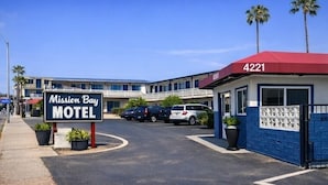 Un motel con un cartel que dice 'Mission Bay Motel' y el número de edificio '4221'.