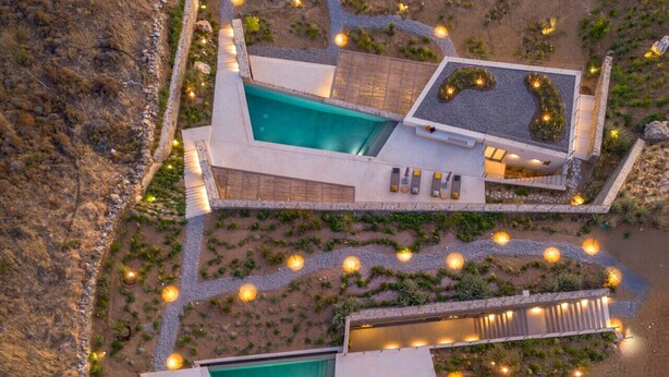 Un complexe hôtelier moderne doté de deux piscines, d’un espace extérieur aménagé et offrant un paysage désertique.