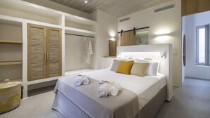 Une chambre avec un grand lit, une armoire intégrée et un miroir.