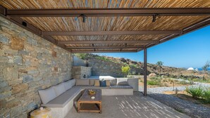 Un espace extérieur abrité, doté de murs en pierre et offrant une vue sur le paysage.