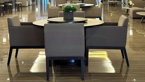Eine moderne Hotellobby mit einer zentralen Sitzecke, einer Wand mit Vogelmotiven und einem polierten Boden.