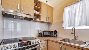 Una cocina moderna con estufa integrada, microondas y cafetera.