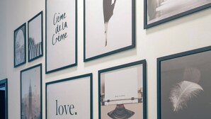 A wall with framed artwork including a cityscape, a feather, and a quote 'love.' - Nahualli Hospedaje Boutique /5 recámaras céntrico (Zacatlán)