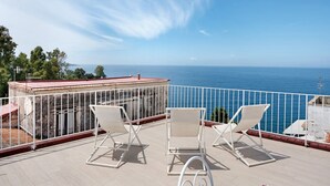 Ein Balkon mit zwei weißen Stühlen und Blick aufs Meer.