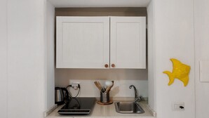 A compact kitchen with white cabinets, a coffee maker, a toaster, a sink, and a dishwasher. - Apartment 'Yellow Room' with Sea View, Wi-Fi and Air Conditioning (Meta)