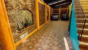 A covered outdoor area with a brick wall, patterned floor tiles, and a staircase. - Downtown Apt / Walk to Main Square / Families & Groups (Zacatlán)