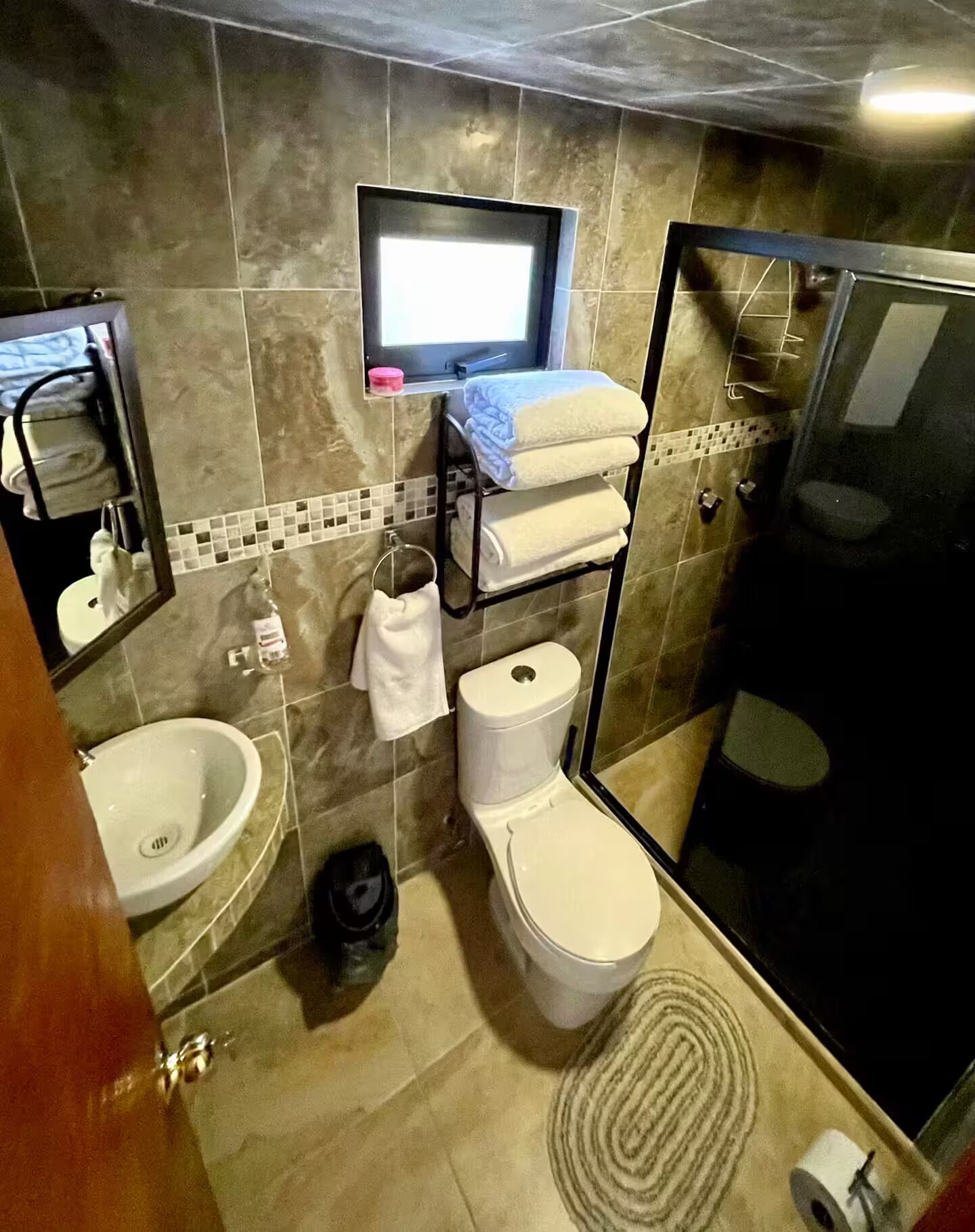 A bathroom with a toilet, bidet, sink, and a mirror.