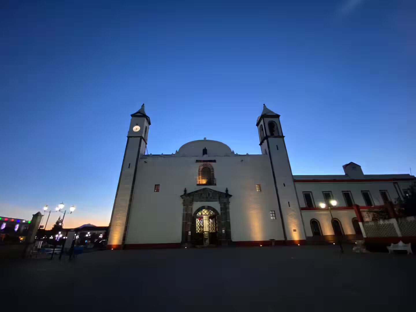 A large building with two towers and a central dome, featuring a prominent entrance with a decorative arch.