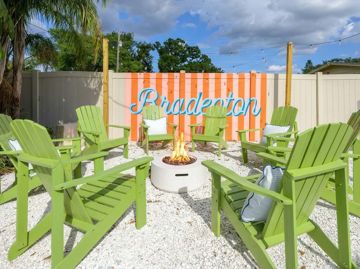 Eine Terrasse mit grünen Adirondack-Stühlen, einer Feuerstelle und einem Zaun, auf dem 'Bradepton' steht.