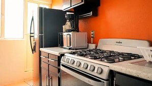 A kitchen with a stove, microwave, and coffee maker. - Quiet Family Apartment 2 Blocks from Zacatlán Downtown (Zacatlán)