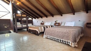 Un dormitorio con dos camas, una litera de madera, suelo de baldosas y techo inclinado.
