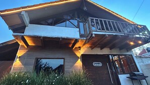 Un edificio de dos pisos con un balcón, una terraza de madera y un letrero que dice 'Homemade'.
