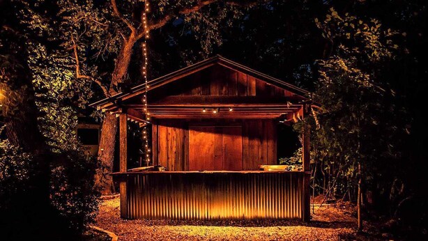 Eine Holzhütte mit Veranda, umgeben von Bäumen.