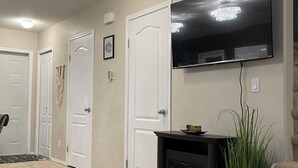 A living room with a flat-screen TV, a fireplace, and a staircase. - Tranquil Candle Lake Townhouse Backing the 5th Green (Candle Lake)