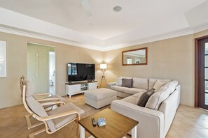 Una sala de estar moderna con un sofá, un sillón, un reposapiés y una mesa de centro.