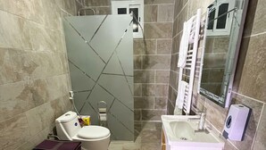 A bathroom with a toilet, bidet, and bathtub.