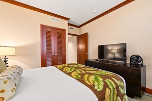 Ein Hotelzimmer mit einem Bett, einem Fernseher, einem Schminktisch und einer Tür.