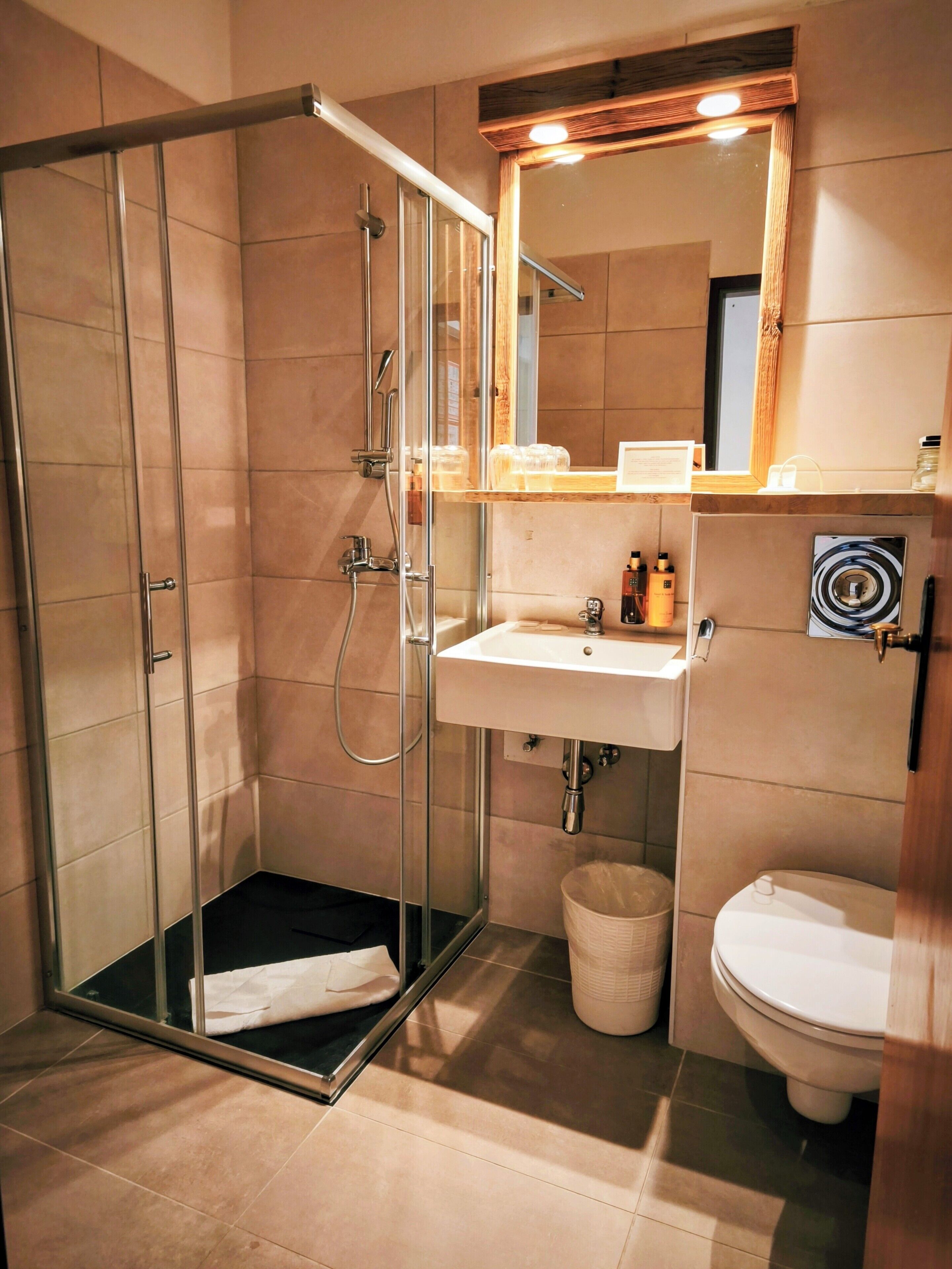 Ein modernes Badezimmer mit einer gläsernen Duschkabine, einem Waschbecken und einer Toilette.