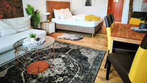 A modern bedroom with a bed, bedside table, lamp, and a wall-mounted deer picture.