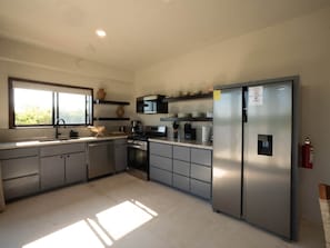 Una cocina moderna con electrodomésticos de acero inoxidable, una ventana y estanterías empotradas.